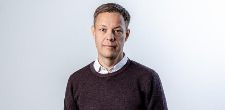 Pressefoto af Bo Juul Jensen i profil med grå baggrund. 
