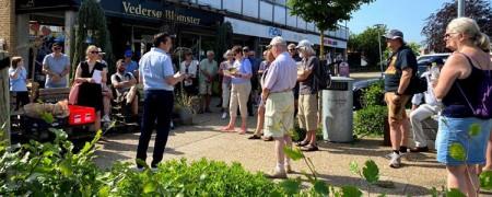 Foto af borgmester Frands Fischer, som står foran en flok mennesker i Galten og fortæller. 